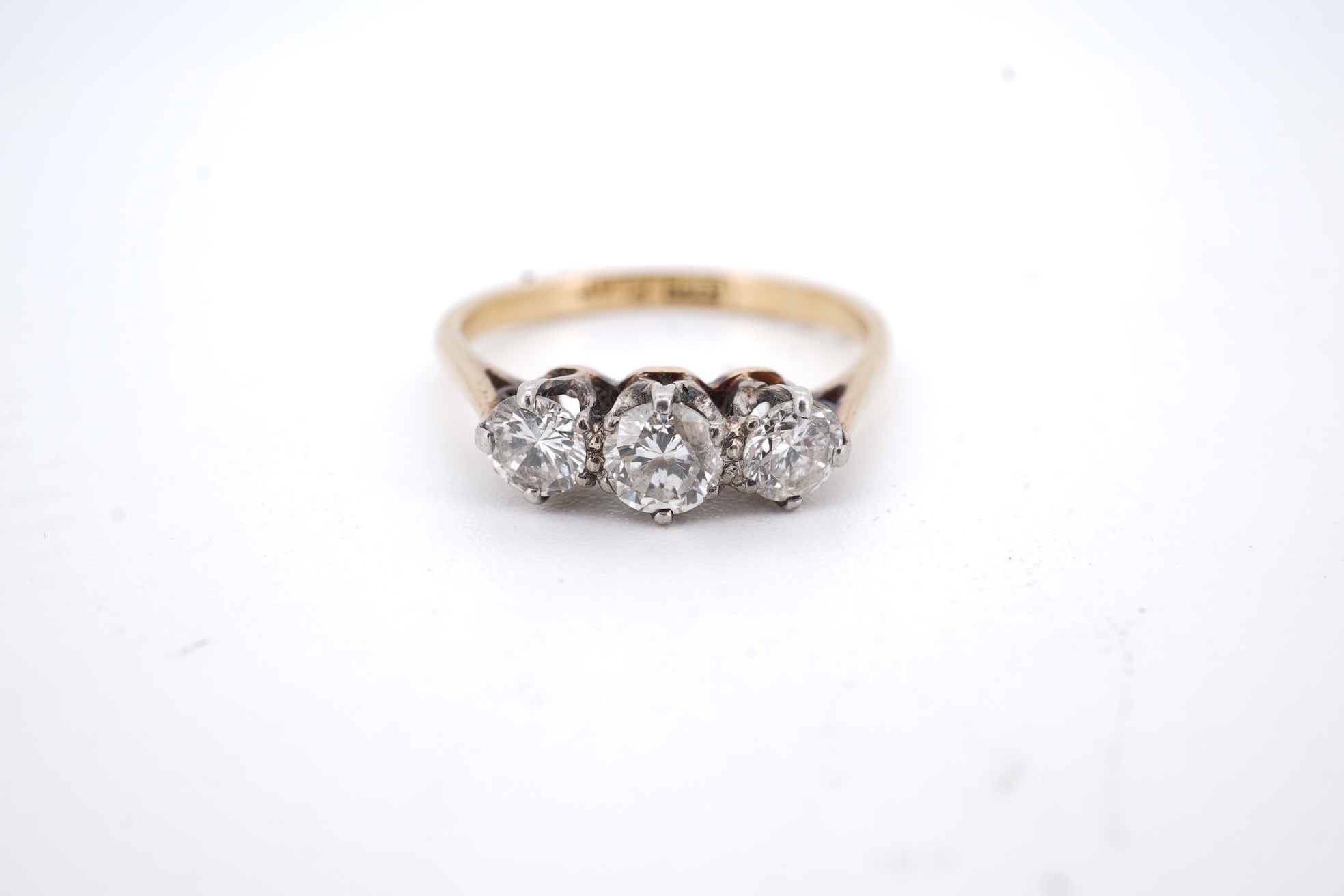 A yellow metal (stamped 18ct, & plat) and three stone diamond set ring, size L, gross weight 2.1 grams.